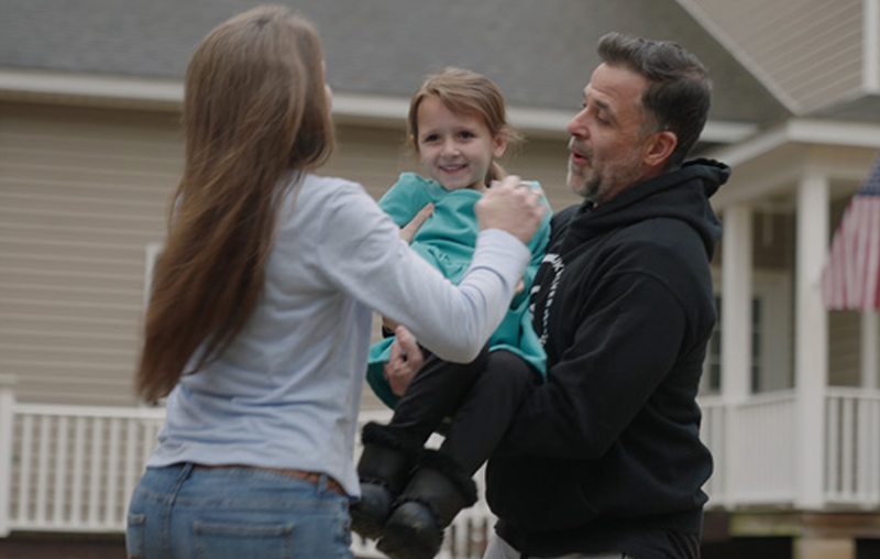 parents smiling holding child with sma