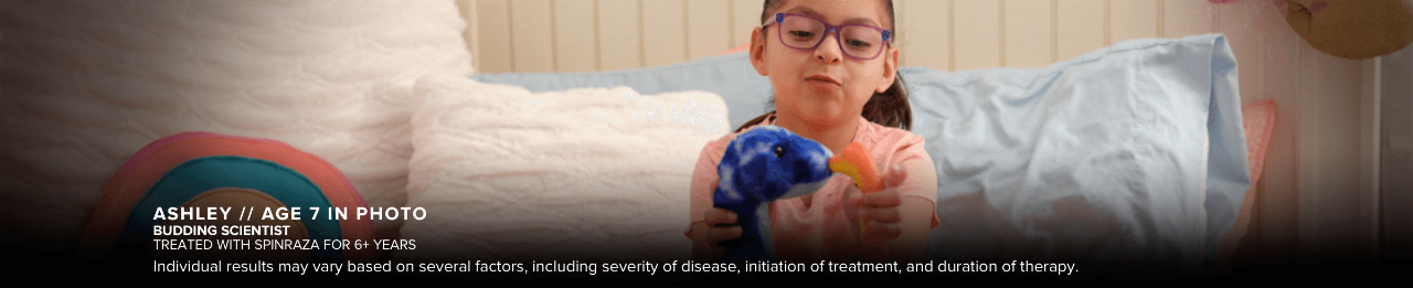 Ashley, age 7 in photo, playing with toys. Has SMA and has been treated with SPINRAZA for 6+ years.